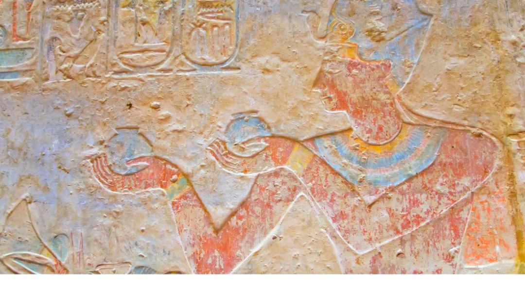A painted Ancient Egyptian relief depicting figures and offerings