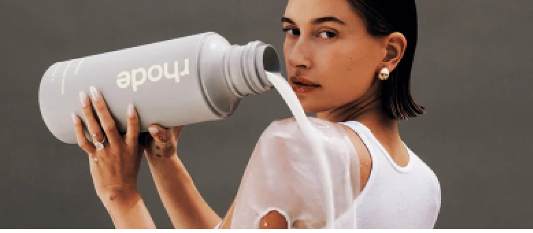 A model pouring rhode glazing milk over her shoulder